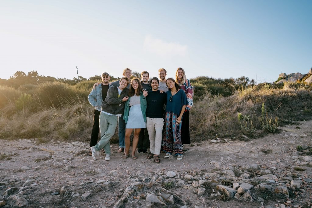 group of young people standing in front of a bush