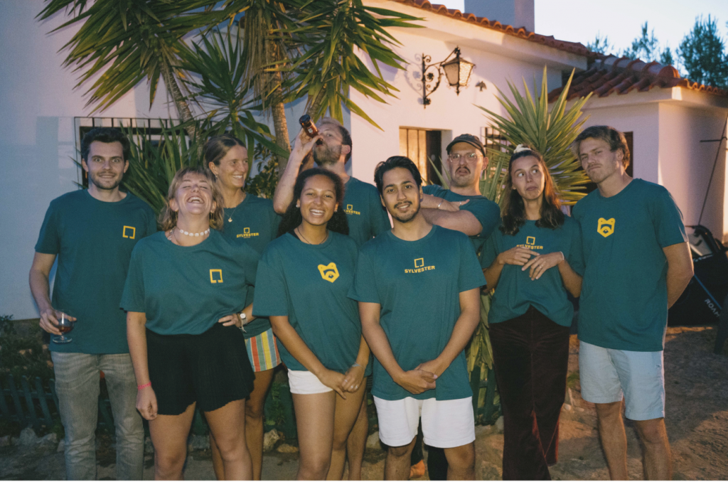 A group of young people in green shirts posing together.