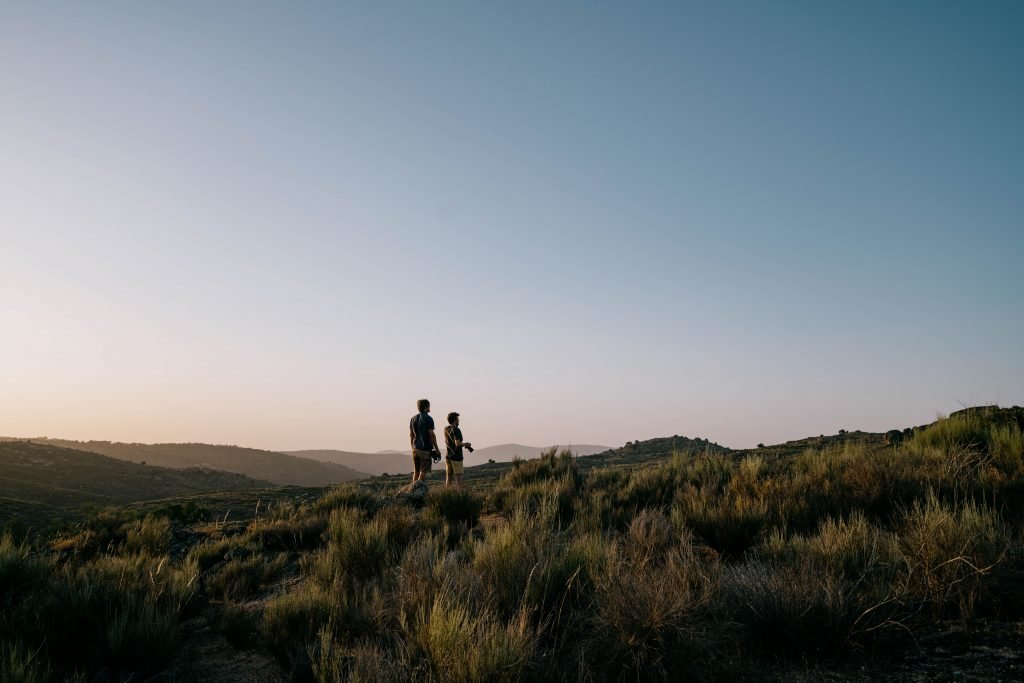two people standing in a open landscape