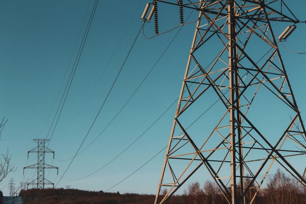 Power lines running in front of a blue sky.
